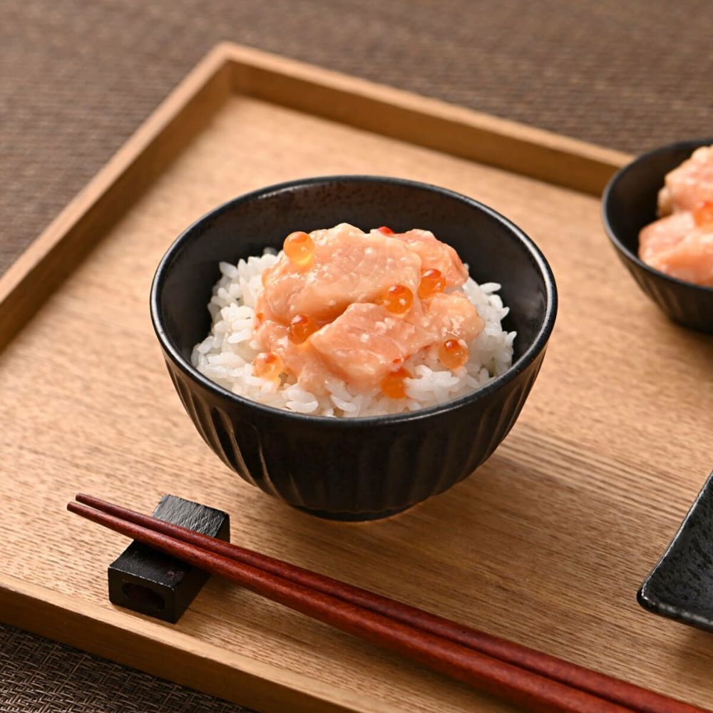 サーモン塩麹漬け　いくら入り　1kgを白米の上に乗せている。木製のお盆に黒いお茶碗。