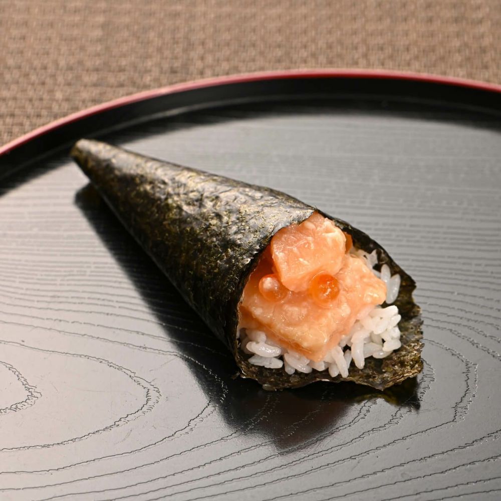 サーモン塩麹漬けを海苔と米で巻いている。手巻き寿司。